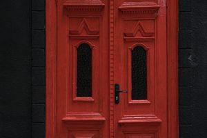 Red vintage door on black wall background Classic entrance doors for houses and mansions as a decoration of the entrance